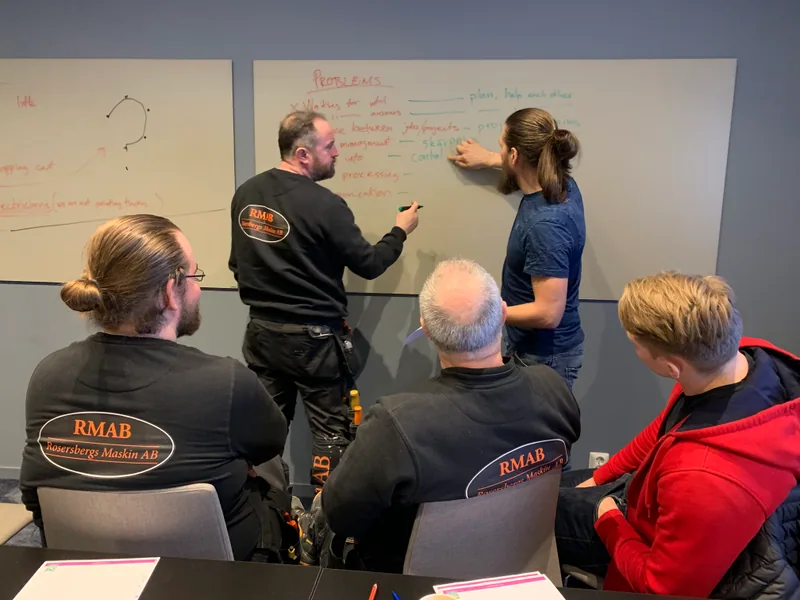Projektgenomgång med entreprenör och beställare vid whiteboard